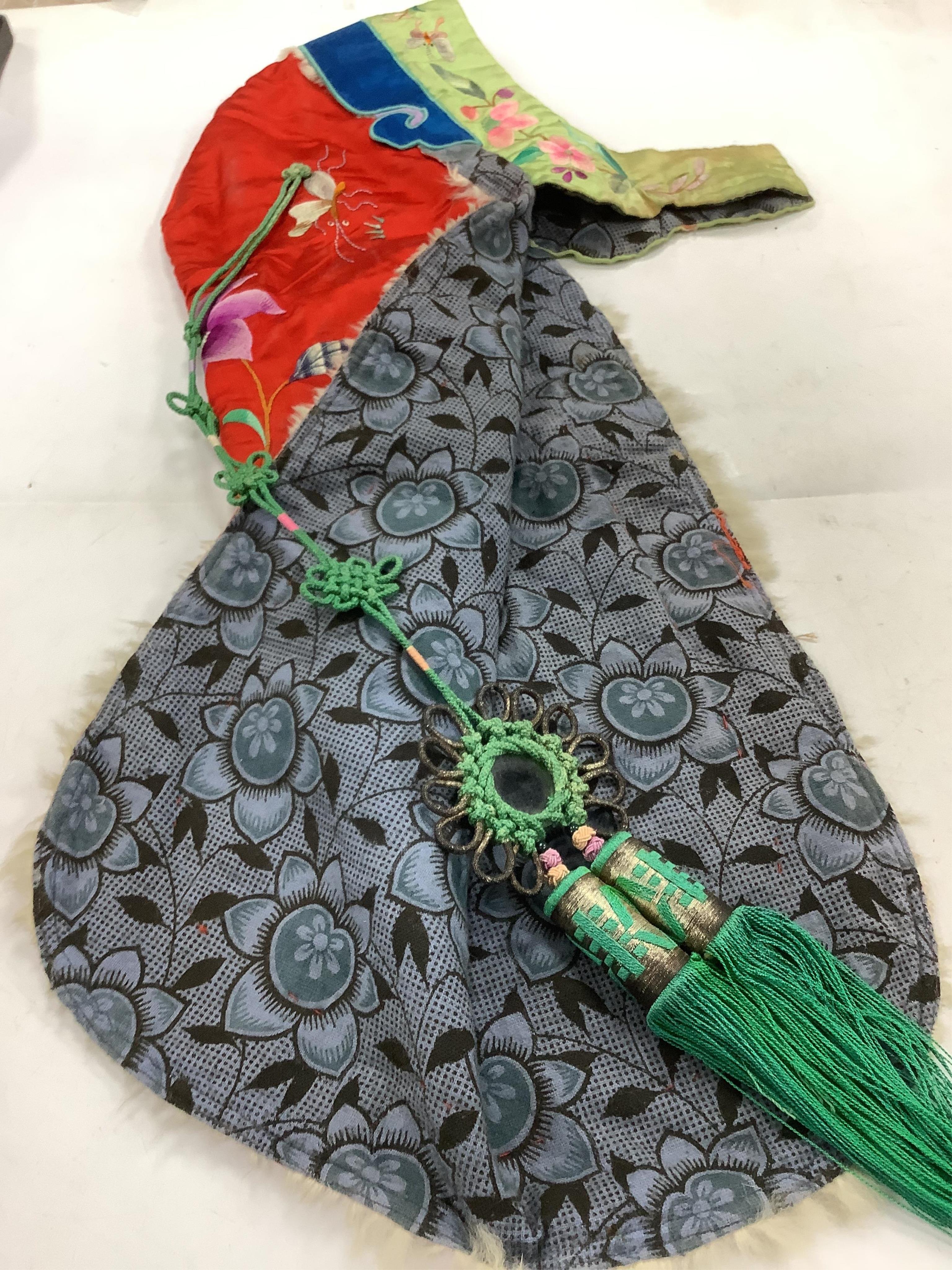 A 20th century possibly Miao, child’s multi coloured silk embroidered and padded winter hood, with fur trim and ornate tasselled decoration, 54cm long. Condition - the light green silk edge has worn and has lightly disco